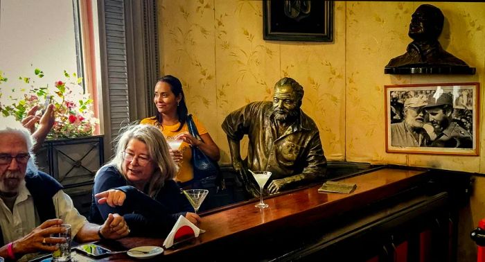 Tourists sip cocktails beside a statue of American author Ernest Hemingway at El Floridita in Havana, Cuba.