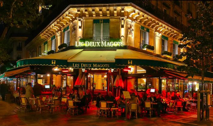 Diners enjoying their experience at the iconic café Les Deux Magots, Blvd St-Germain, Paris, France