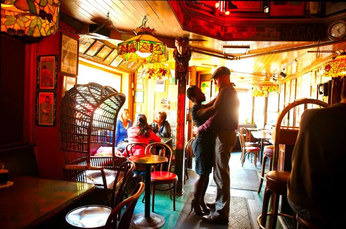 A couple shares a dance in a lively bar