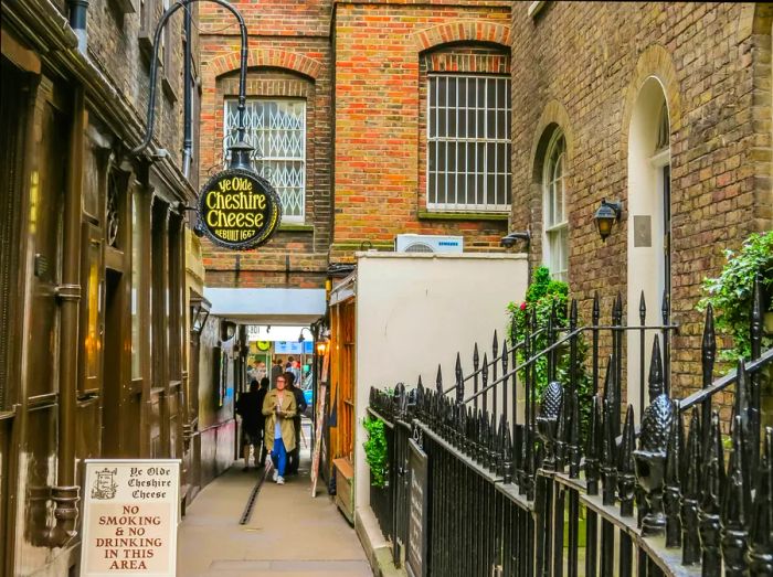 A historic brick-lined alleyway, just off a bustling modern street