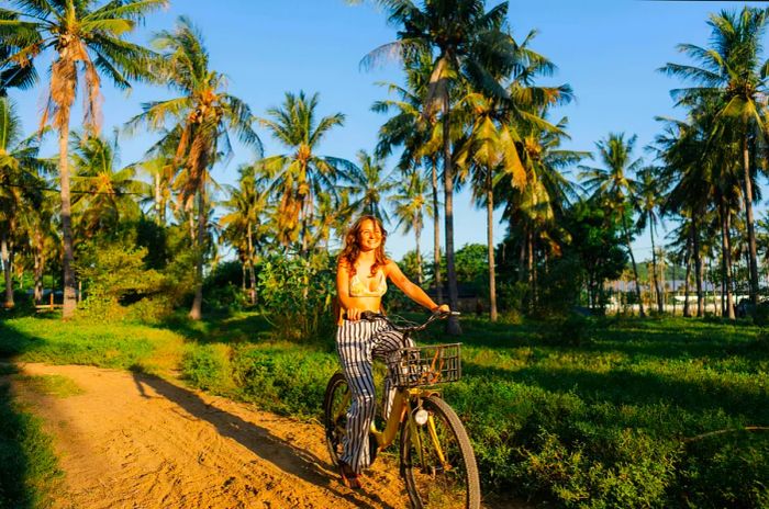 A cyclist navigates through the lush greenery of a coconut grove