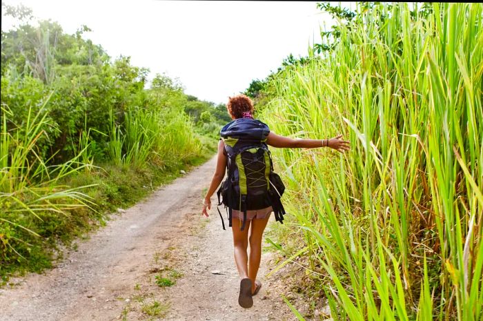 A backpacker strolling along a dirt road in Jamaica