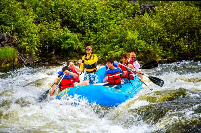 Rafters tackle thrilling rapids on a large raft in a river.