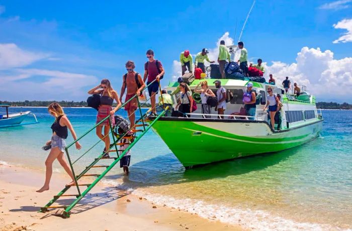 Western travelers arriving via speedboat at Gili Trawangan, the largest of Lombok's Gili Islands, Indonesia.