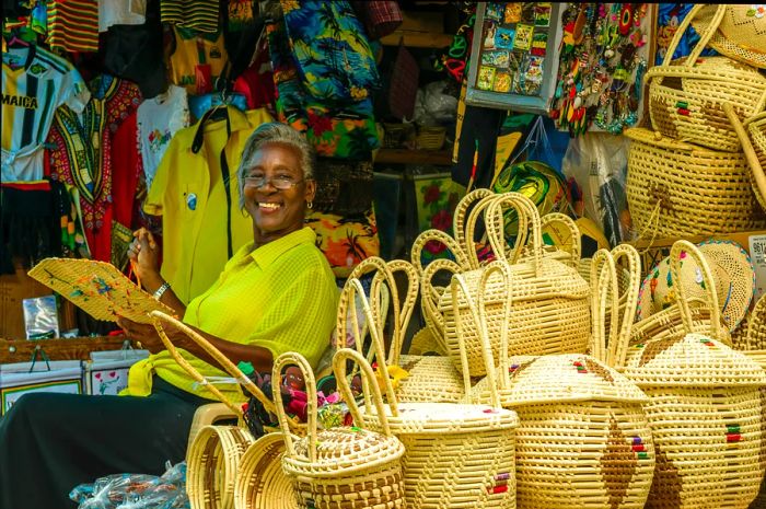 A woman beams while weaving baskets at her market stall in Montego Bay, Jamaica