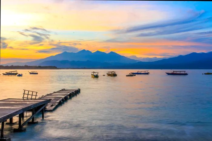 A scenic view featuring a jetty with a mountain range in the background.