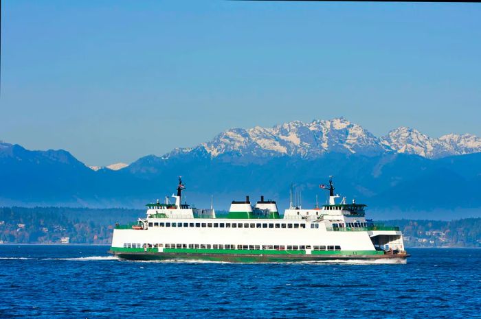 A car and passenger ferry crossing Puget Sound, with the Olympic Mountains in the backdrop.