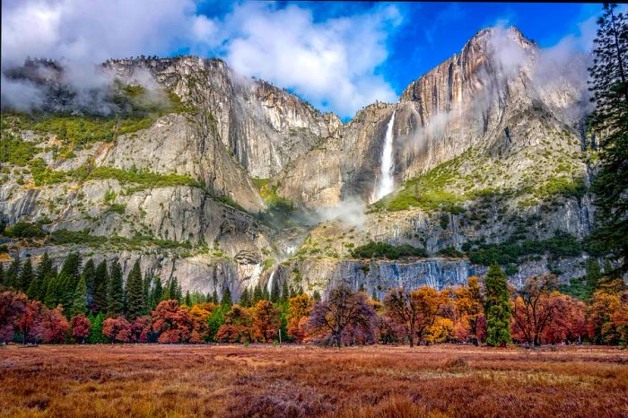 A slender waterfall cascades dramatically from a high rocky outcrop