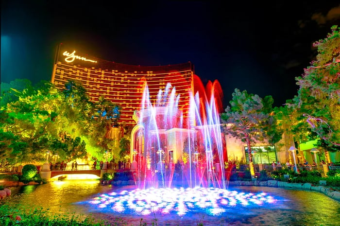 Fountains illuminated at night in front of a casino