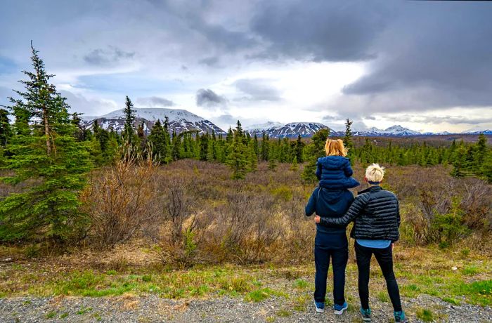 A family of three enjoying the stunning scenery at Denali National Park, Alaska