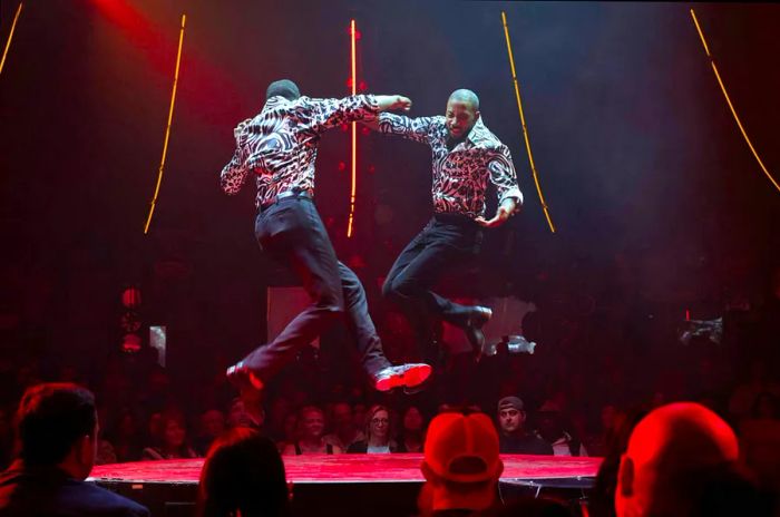 Twin brothers Sean and John Scott showcase their tap dancing skills on a small circular stage during