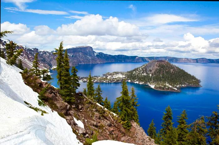 A stunning view of a snow-capped island in an alpine lake