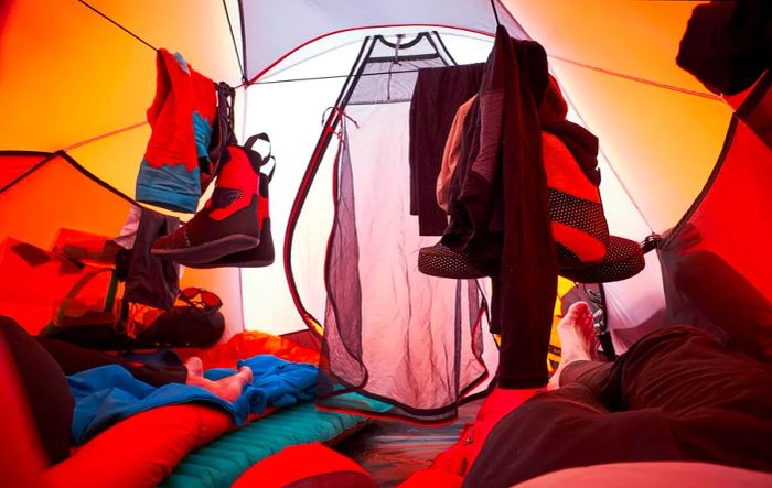 Climbing gear dries in the tent as climbers relax on their sleeping bags during an ascent of Denali.