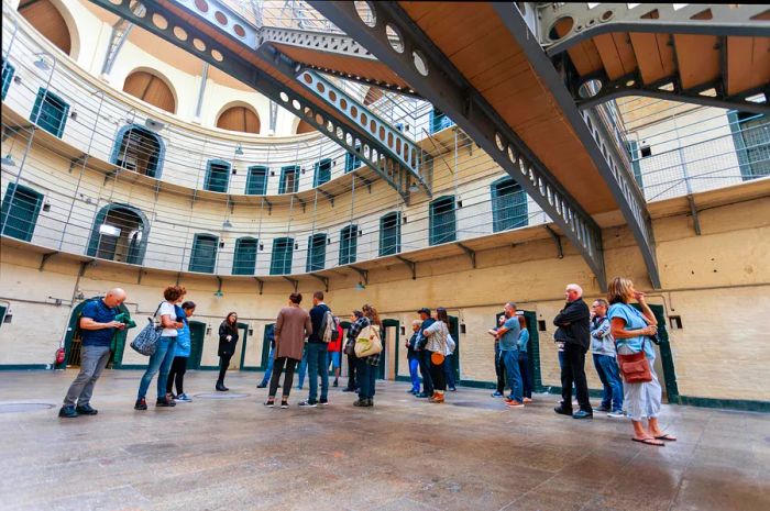 A group of tourists exploring a guided tour of a Victorian prison.