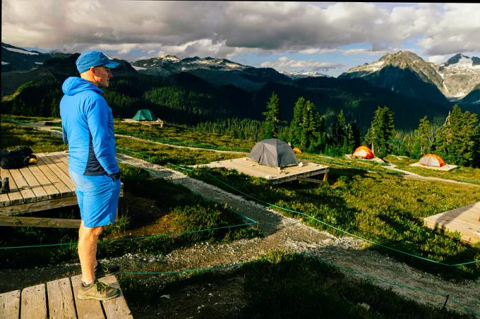 A camper gazes at the stunning alpine landscape near Elfin Lake in Garibaldi Provincial Park, British Columbia, Canada