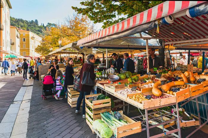 The renowned Marche Aux Fleurs Cours Saleya located in Place Charles Felix, Nice, showcases vibrant fruits and vegetables displayed at the stalls.