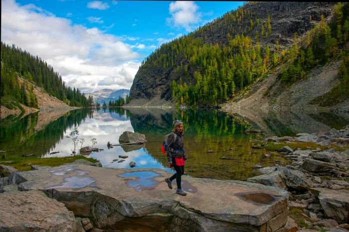 A woman hikes alongside Lake Agnes in Banff National Park, Alberta, Canada.