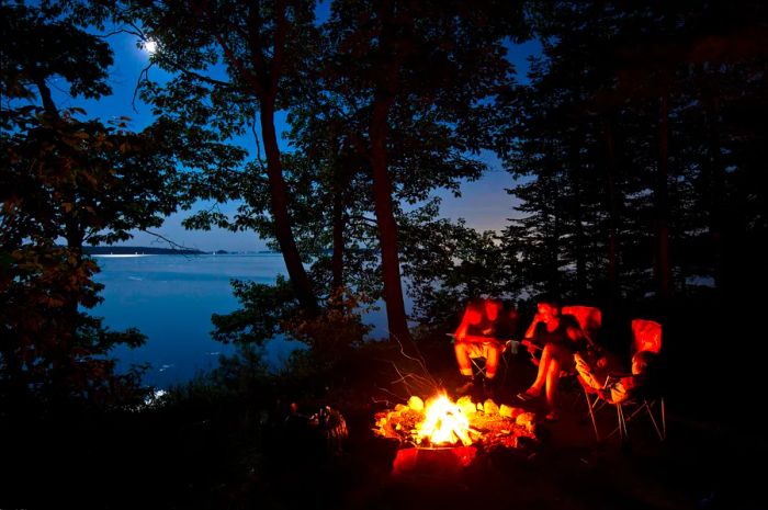 A family enjoying an evening campfire in Maine, USA