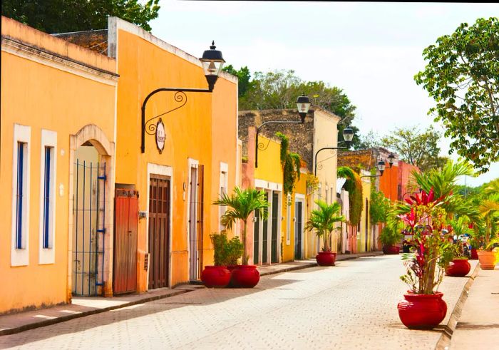 A line of colonial-style houses with terraced designs, adorned in soft pastel yellows and oranges