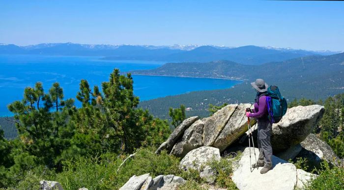 A hiker takes in the view across a serene lake