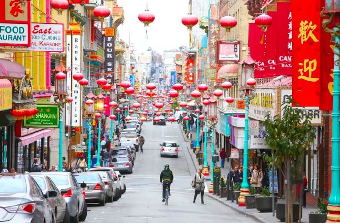 A cyclist rides down Grant Ave in Chinatown, San Francisco, California, USA