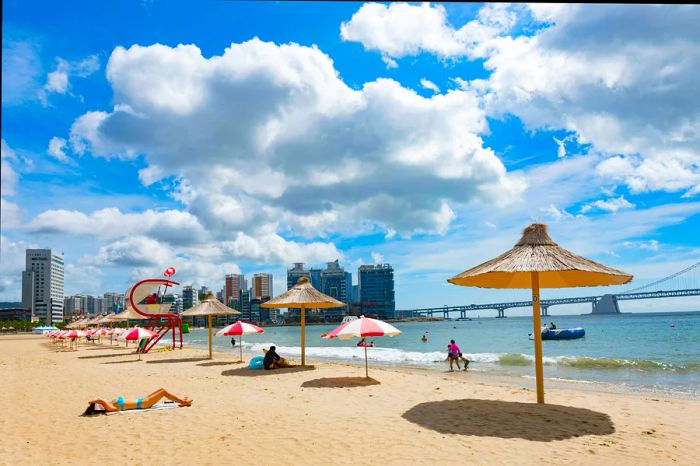 Visitors enjoy leisure time on Gwangalli Beach in Busan, South Korea.