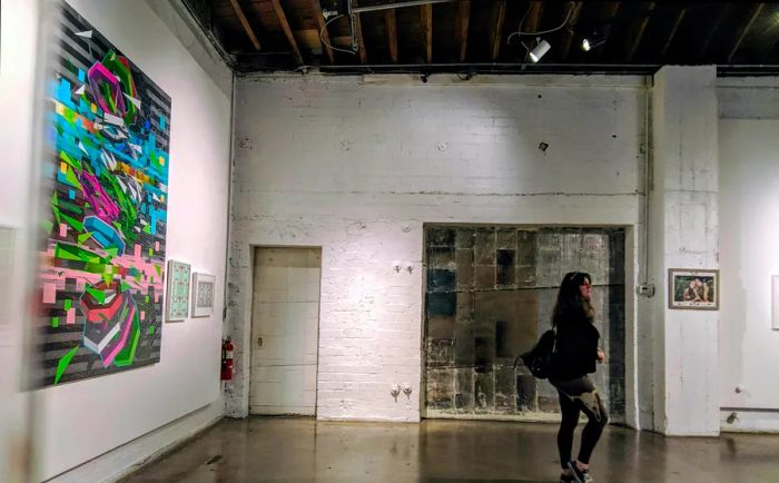 A woman strolls through an art gallery