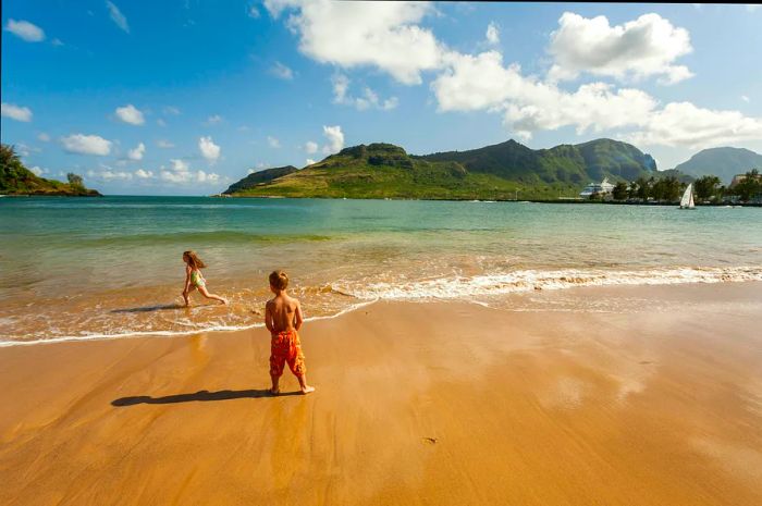 Young children play in the waves at Kalapaki Beach near the Kauai Marriott Resort