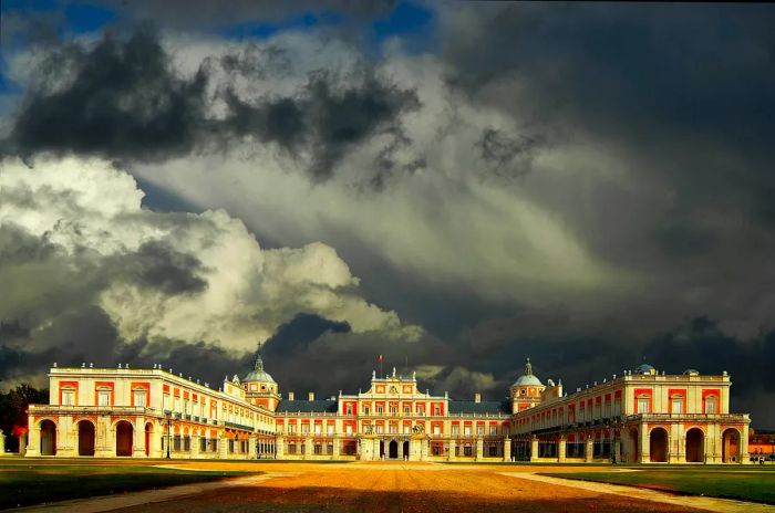 A striking red-and-white brick palace under a grey, stormy sky