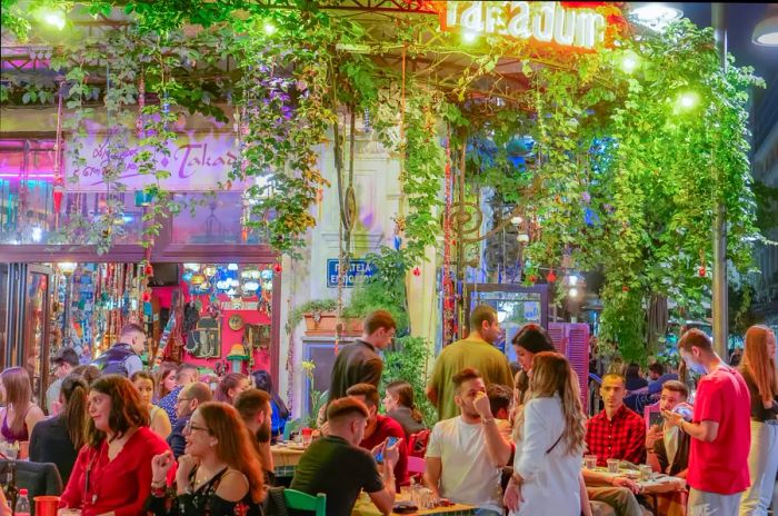 Diners enjoying meals at outdoor tables in the Ladadika district, Thessaloniki, Macedonia, Greece