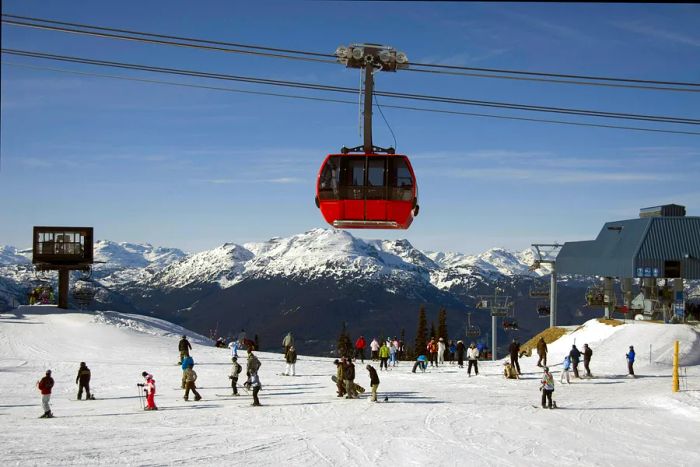 The Peak 2 Peak gondola glides over skiers navigating the slopes in Whistler, British Columbia, Canada.