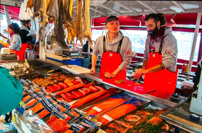 Two fresh fish vendors in red aprons at the fish market.