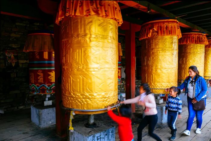 A woman and three children are seen spinning a prayer wheel at the Tibetan-style National Memorial Chorten, one of Thimphu's most prominent religious sites.