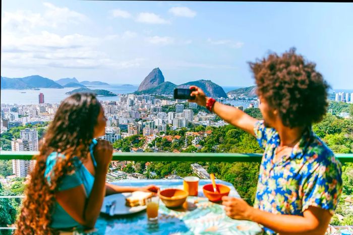 A Brazilian couple relaxes at a terrace table overlooking Sugarloaf Mountain in Rio de Janeiro, Brazil.