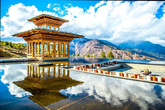 A tranquil spot by a pool in Thimphu, Bhutan, on a sunny day, where the clouds above are mirrored in the water.