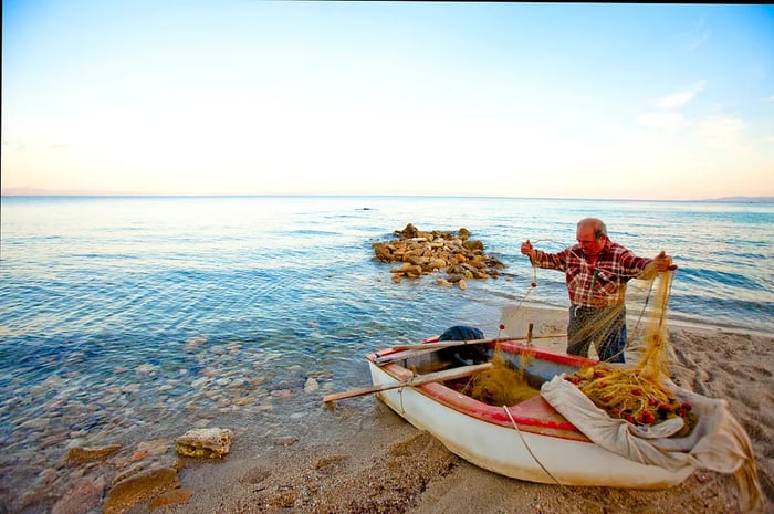 An elderly Greek fisherman rows out to sea from a quaint village on the eastern coast of Northern Greece, just south of Thessaloniki.