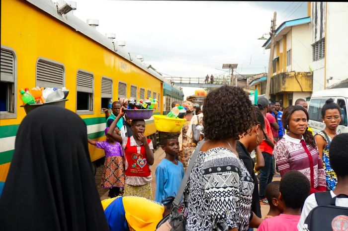 Travelers waiting on the platform at a train station in Lagos, Nigeria