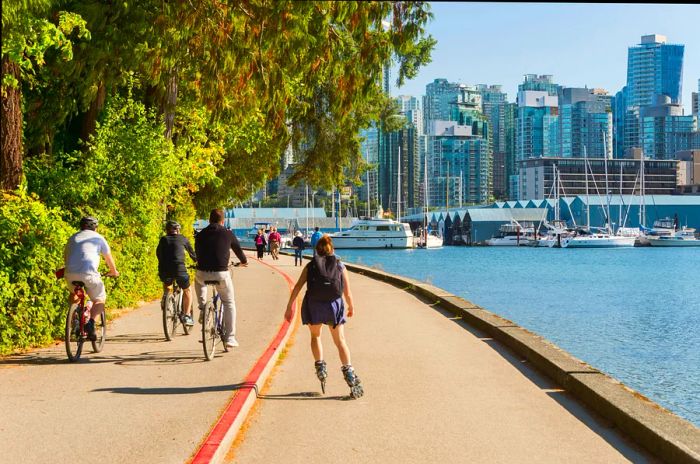 Rollerbladers and cyclists enjoying the Stanley Park seawall.