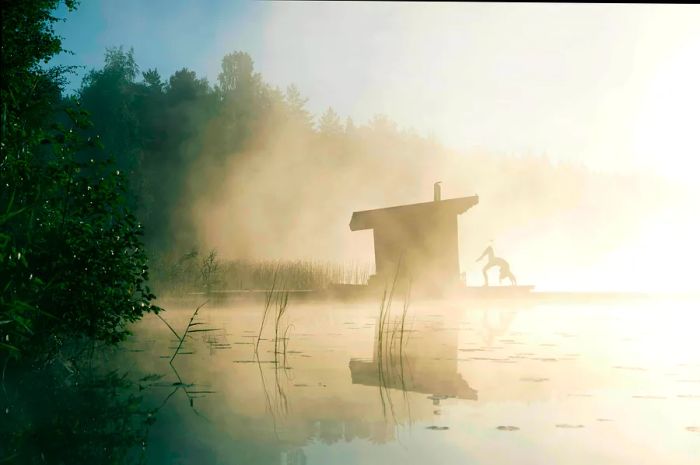 A person practicing a yoga pose on a wooden dock by a misty lake, with the bright morning sun illuminating the scene while fog partially veils the surrounding nature.