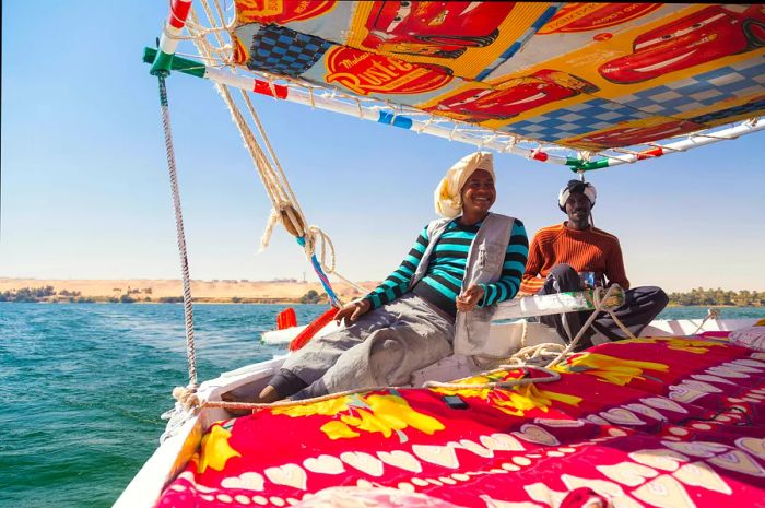 Nubian felucca sailing crew taking tourists on a Nile adventure