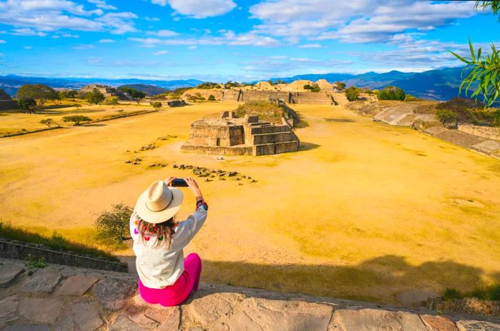 A woman enjoys the view from a high point above Monte Albán, an archaeological site in Oaxaca, Mexico