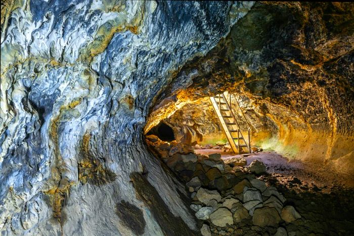 A wooden ladder leads up to the entrance of Golden Dome Cave at Lava Beds National Monument.