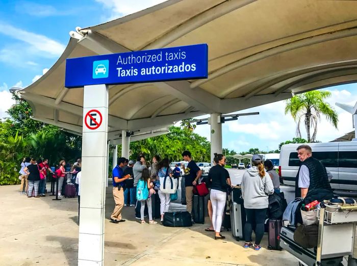 Newly arrived tourists waiting in line for taxis outside Cancun International Airport.