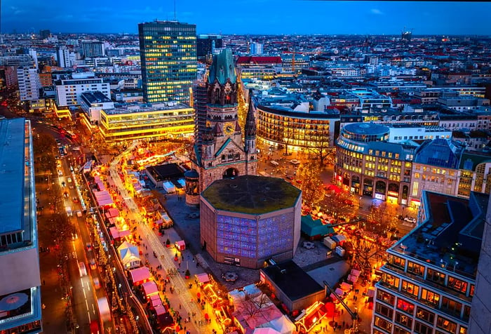 Aerial evening view of the City Center West skyline in Berlin, featuring the Memorial Church and a Christmas market during the Advent season