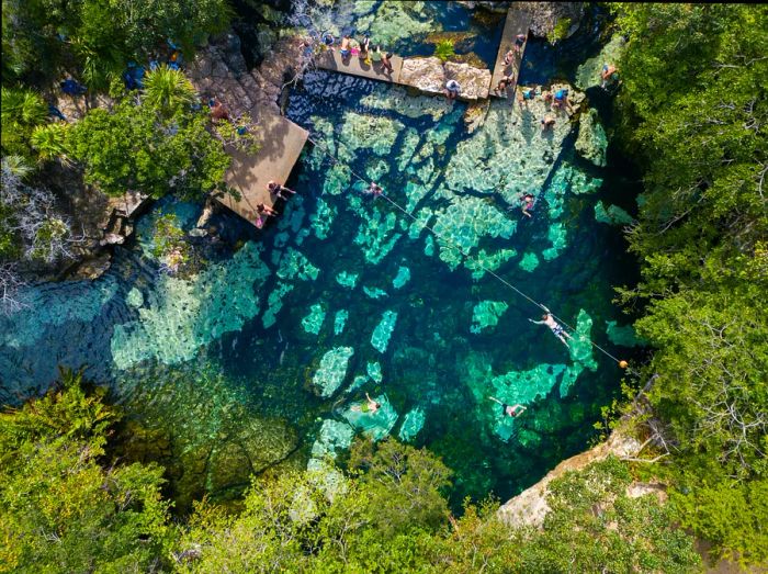 An overhead view of Cenote Azul in the Riviera Maya with swimmers enjoying the water