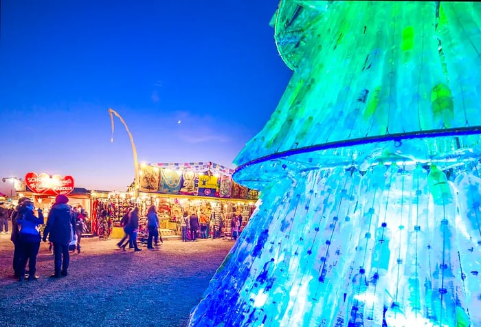 A Christmas tree crafted from recycled bottles, adorned with seasonal shops.