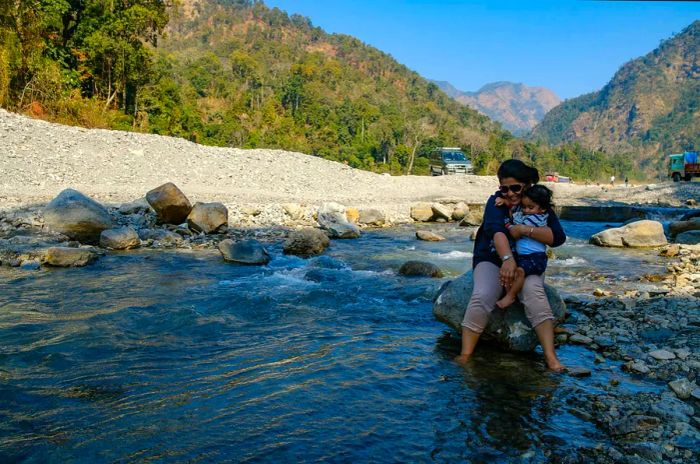 A mother and toddler enjoying a stream in the mountains