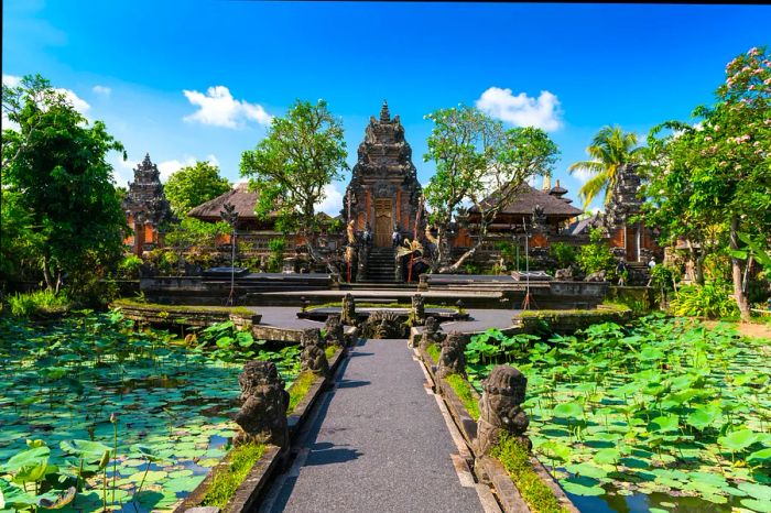 A walkway bordered by lily-covered ponds leads to a temple structure