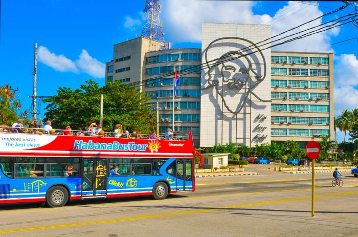 A blue-and-red sightseeing bus tours around Plaza de la Revolucion (Revolution Square) in Havana.