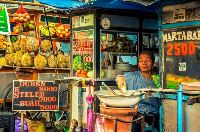 A local street vendor transporting her goods on August 25, 2015, in Bali, Indonesia. These vendors earn a living by selling snacks.